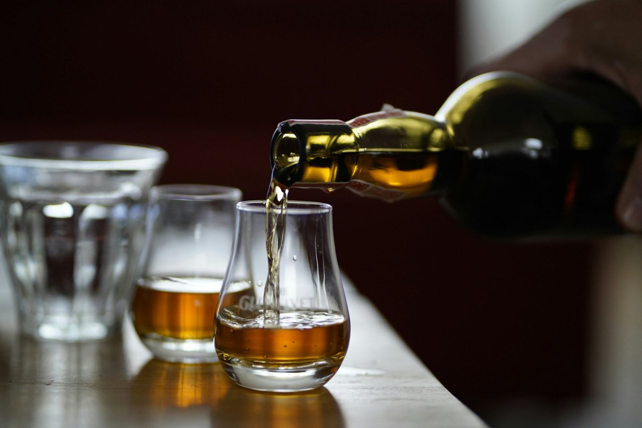 pouring whiskey into a glass 